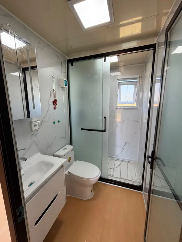 Baño completo de la casa modular con mampara, inodoro y vanitory