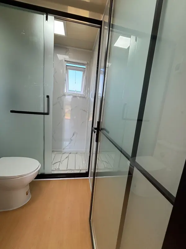 Ducha con mampara de vidrio y ventana